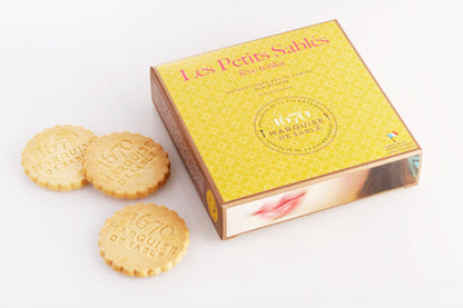 Box of 'Les Petits Sablés' cookies with two cookies on a white background